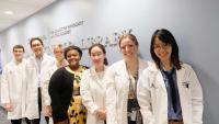 Faculty and two pathology residents looking through microscopes